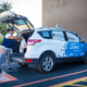 A Walmart employee loading groceries into a Ford test vehicle.